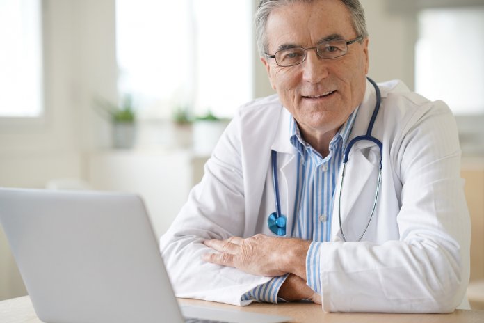 Portrait of senior doctor sitting in medical office