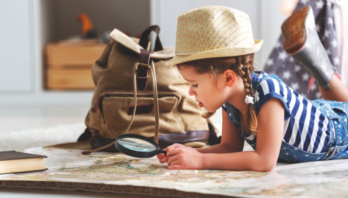 funny child girl tourist with world map, backpack and magnifier