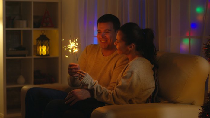 romantic-young-couple-holding-fireworks-UH88YHZ-scaled